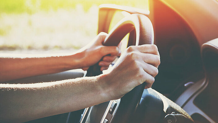hands on steering wheel driving car