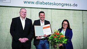 PD Dr. Ortwin Naujok nach der Preisverleihung, flankiert von Laudator Professor Dr. Markus Tiedge und Vanessa Schäfer von Roche Diabetes Care Deutschland. | Foto: DDG/Dirk Deckbar